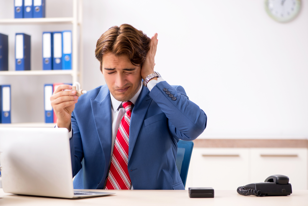 Person struggling to hear at work.